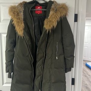 Green warm women’s zip up winter jacket with rabbit fur hood.